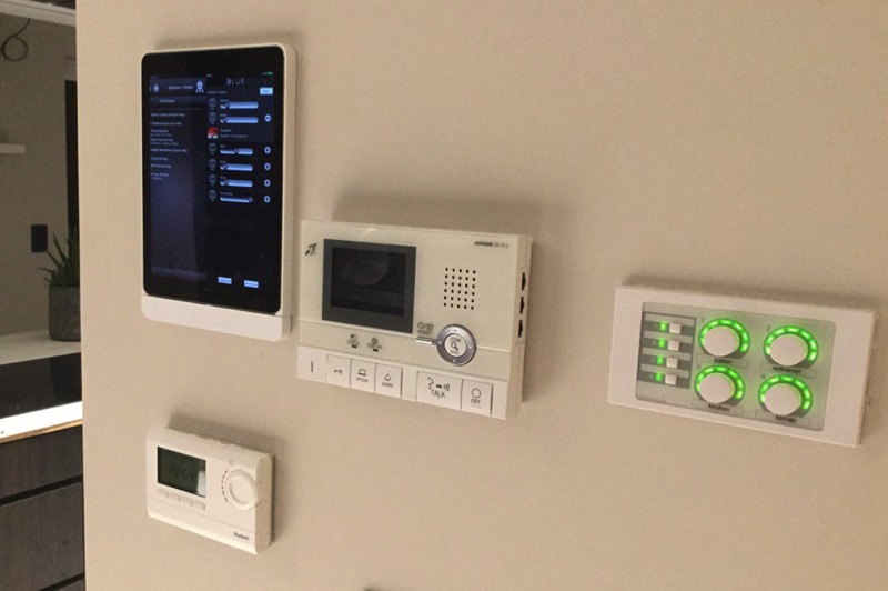 foto die de bediening met een app en wandpaneel van een multiroom installatie bestaande uit zes zones laat zien